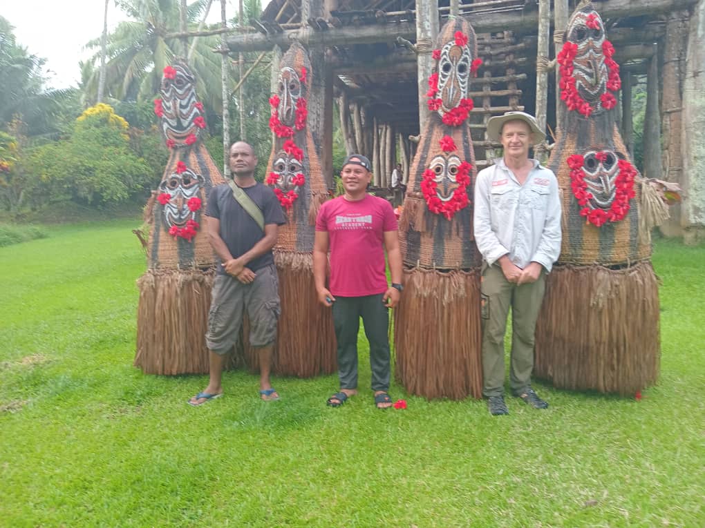 Borderlands Green Ltd team members standing with traditional spirit dancers in East Sepik, Papua New Guinea.