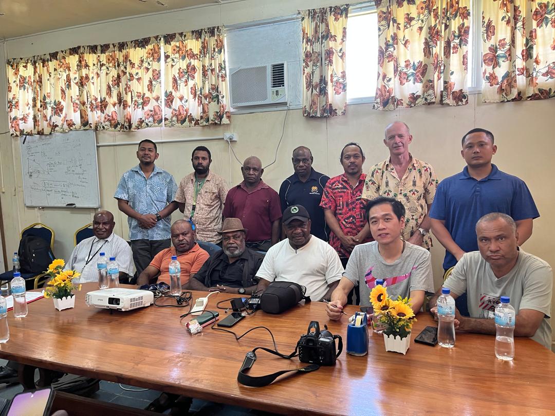 Group photo of community leaders and project partners during indoor environmental planning session