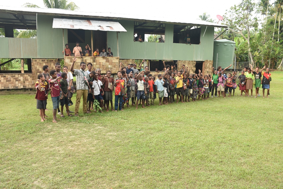 Students and teachers of Kanganamun Primary School standing together in front of their school building in East Sepik Province, Papua New Guinea.